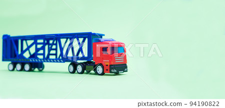 Toy car transporter with cars on a green background with place for text, copy space, for a toy store. Toy car transporter with cars on a green background with place for text, copy space, for a toy store. 94190822