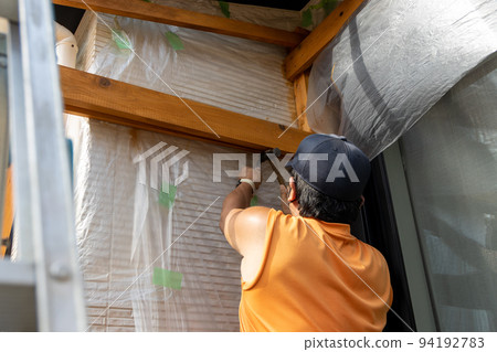 Do-it-yourself man building a wooden pergola 94192783