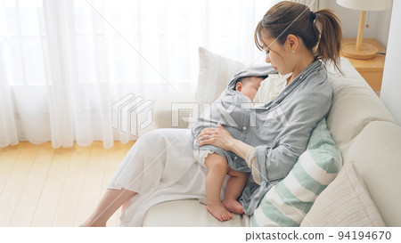 Women breastfeeding with a nursing cover Women breastfeeding with a nursing cover 94194670