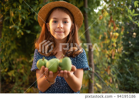 Organic agriculture. Portrait of cute little girl holds a passion fruit crop in her hands. The concept of harvesting and farming 94195186