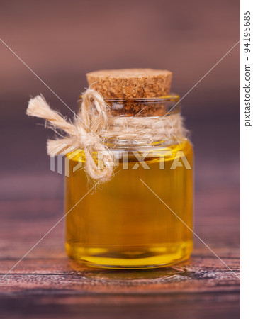 Oil in a glass jar on wooden background. For cosmetic and beauty products. Oil in a glass jar on wooden background. For cosmetic and beauty products. 94195685