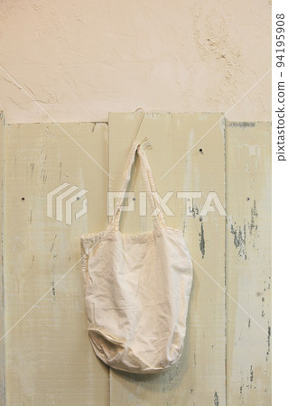 A cotton eco bag hanging on a wooden wall A cotton eco bag hanging on a wooden wall 94195908
