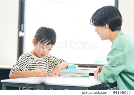 A woman who teaches studying Elementary school students studying 94196033