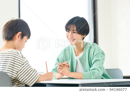 A woman who teaches studying Elementary school students studying 94196077