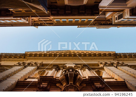 Narrow street and high buildings perspective view in Valetta Narrow street and high buildings perspective view in Valetta 94196245