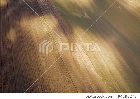 Aerial drone view of plowed agricultural terrain Aerial drone view of plowed agricultural terrain 94196275