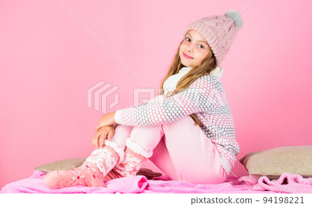 Girl long hair relaxing pink background. Winter fashion for children. Kid smiling fashion model. Kid girl wear cute knitted fashionable hat and comfortable cozy clothes. Winter fashion concept 94198221