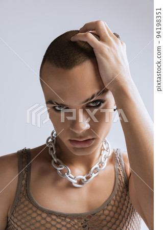 Close-up portrait of young man with smoky eyes makeup posing isolated over grey studio background Close-up portrait of young man with smoky eyes makeup posing isolated over grey studio background 94198351