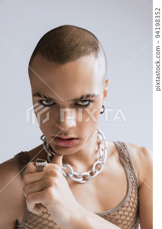 Close-up portrait of stylish young man with makeup posing isolated over grey studio background. Male expression Close-up portrait of stylish young man with makeup posing isolated over grey studio background. Male expression 94198352
