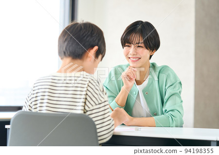 A woman who teaches studying Elementary school students studying 94198355