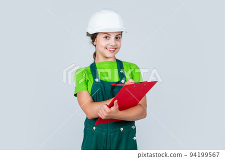 Little kid in helmet with tablet. Repair planning. kid in hard hat making notes. child hold document folder. Kid learn how to be a construction worker builder with safety hat 94199567