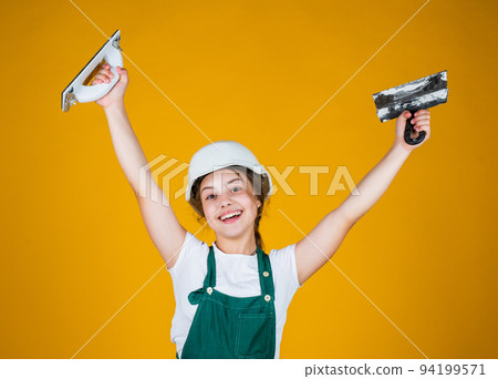 happy kid engineer with plastering tool spatula in hard hat, inspector 94199571