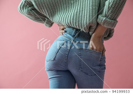 Woman wearing jeans on pink background, closeup Woman wearing jeans on pink background, closeup 94199933