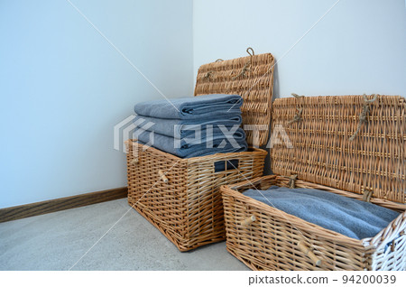 Stack navy blue bath towels in wicker basket on the floor. copy space. Stack navy blue bath towels in wicker basket on the floor. copy space. 94200039