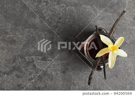 Aromatic homemade vanilla extract on grey table, top view. Space for text 94200569
