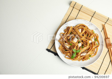 Tasty buckwheat noodles with meat served on white table, flat lay. Space for text Tasty buckwheat noodles with meat served on white table, flat lay. Space for text 94200697
