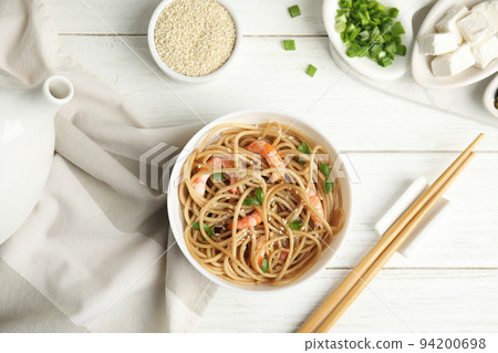 Tasty buckwheat noodles with shrimps served on white wooden table, flat lay Tasty buckwheat noodles with shrimps served on white wooden table, flat lay 94200698