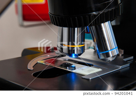 Closeup of a slide been analyzed under a fluorescence microscope in a genetics laboratory 94201041