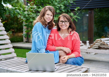 Portrait of happy mom and teenage daughter looking at camera 94201050