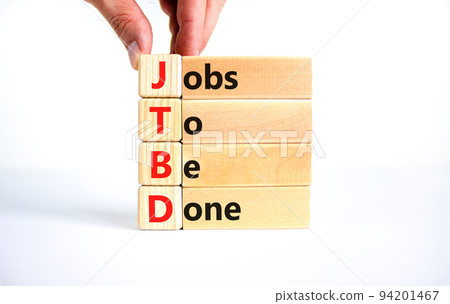 JTBD jobs to be done symbol. Concept words JTBD jobs to be done on wooden blocks on beautiful white background. Businessman hand. Business and JTBD jobs to be done concept. Copy space. 94201467