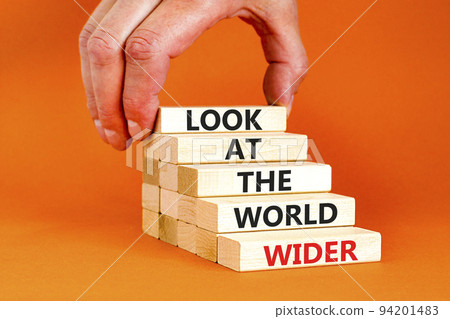 Look at the world wider symbol. Concept words Look at the world wider on wooden blocks on a beautiful orange background. Businessman hand. Business and look at the world wider concept. Copy space. Look at the world wider symbol. Concept words Look at the world wider on wooden blocks on a beautiful orange background. Businessman hand. Business and look at the world wider concept. Copy space. 94201483