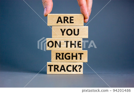 Right track symbol. Concept words Are you on the right track on wooden blocks on a beautiful grey table grey background. Businessman hand. Business motivational and right track concept. Right track symbol. Concept words Are you on the right track on wooden blocks on a beautiful grey table grey background. Businessman hand. Business motivational and right track concept. 94201486