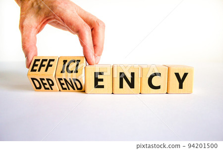 Efficiency or dependency symbol. Businessman turns cubes, changes the word dependency to efficiency. Beautiful white table, white background, copy space. Business, efficiency or dependency concept. Efficiency or dependency symbol. Businessman turns cubes, changes the word dependency to efficiency. Beautiful white table, white background, copy space. Business, efficiency or dependency concept. 94201500