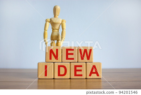 Concept words 'new idea' on cubes on a beautiful wooden table. Wooden model of human. Beautiful white background. Concept words 'new idea' on cubes on a beautiful wooden table. Wooden model of human. Beautiful white background. 94201546