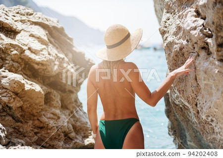 Beautiful blond woman in a straw hat on the beach of Corfu Beautiful blond woman in a straw hat on the beach of Corfu 94202408