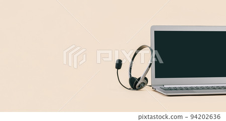 Laptop with headphones on beige desk banner Laptop with headphones on beige desk banner 94202636
