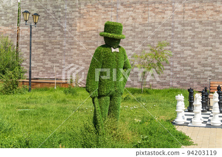 Sculpture made of artificial grass in the city, topiary figure. Selective focus 94203119
