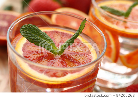 Preparation of chilled orange punch with mint homemade cocktail closeup 94203268