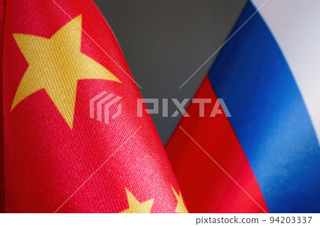 Close-up of Chinese and Russian flags as a symbol of cooperation. Close-up of Chinese and Russian flags as a symbol of cooperation. 94203337