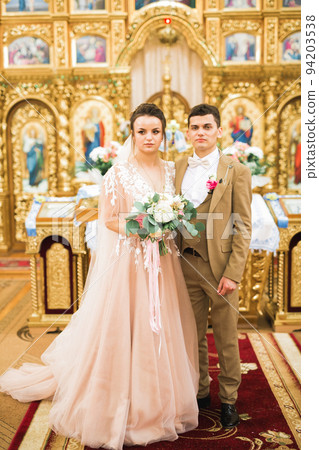 Married couple posing in a church after ceremony Married couple posing in a church after ceremony 94203538