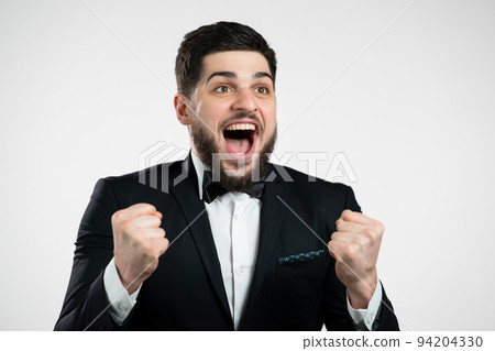 Businessman in tuxedo is very glad and happy, he shows yes gesture of victory, guy achieved result Businessman in tuxedo is very glad and happy, he shows yes gesture of victory, guy achieved result 94204330