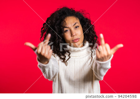 Young woman with african hair on red background showing middle finger - gesture of fuck. Expression 94204598