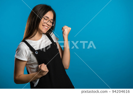 Asian girl with long hair very glad and happy, she shows yes gesture of victory, she achieved result Asian girl with long hair very glad and happy, she shows yes gesture of victory, she achieved result 94204616