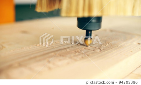Modern CNC router bit engraves wood, close up shot Modern CNC router bit engraves wood, close up shot 94205386