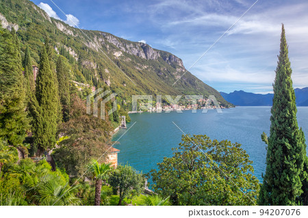 Idyllic Lake Como coastline with village and cypresses at sunny day, Italy 94207076