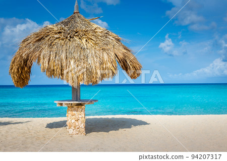 Aruba idyllic caribbean beach at sunny day with rustic palapa, Dutch Antilles 94207317