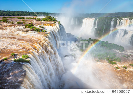 Iguazu Falls dramatic landscape with rainbow, view from Argentina side Iguazu Falls dramatic landscape with rainbow, view from Argentina side 94208067