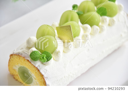Shine Muscat roll cake taken in bright natural light, horizontal position, closer to the white background 94210293