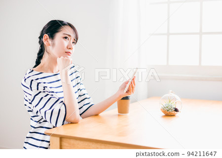 A woman who has trouble reading a smartphone (table) A woman who has trouble reading a smartphone (table) 94211647
