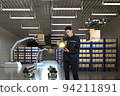 Asian Man Engineer hold smartphone touch touching UI screen interface for manufacturing industry technology Product export and import future Robot cyber warehouse arm robot future technology 94211891