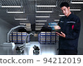 Asian Man Engineer hold smartphone touch touching UI screen interface for manufacturing industry technology Product export and import future Robot cyber warehouse arm robot future technology 94212019