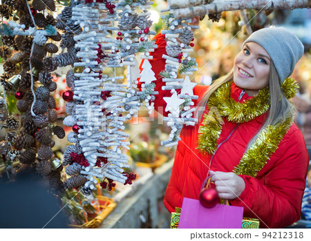 Happy girl chooses Christmas toys on the street market Happy girl chooses Christmas toys on the street market 94212318