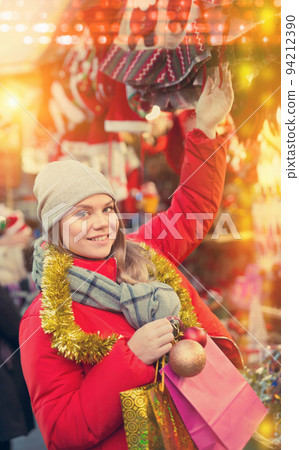 Girl choosing Christmas gifts outdoor on the street market 94212390