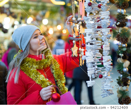 Girl choosing Christmas gifts outdoor on street market Girl choosing Christmas gifts outdoor on street market 94212409