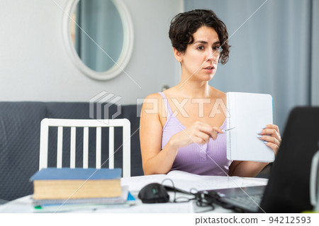 Woman is studying using laptop and internet at home Woman is studying using laptop and internet at home 94212593