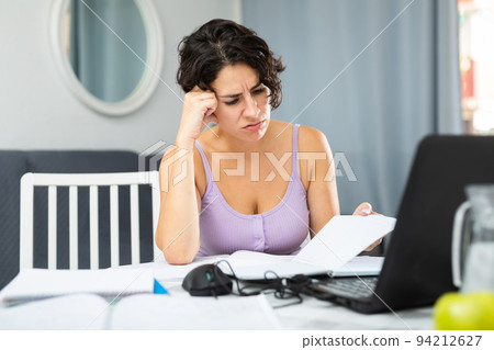 Tired woman working with laptop at home 94212627